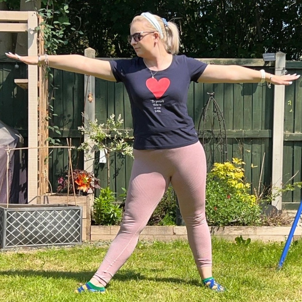 Me performing a simple warrior 2 yoga pose in my garden